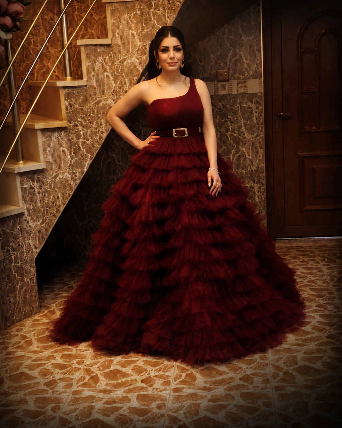 Model wearing a tiered burgundy couture evening gown